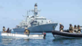 The suspected pirates' skiff is inspected by a Royal Navy and Royal Marines boarding team.
