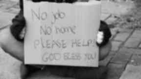 Homeless man with sign on street in black and white generic