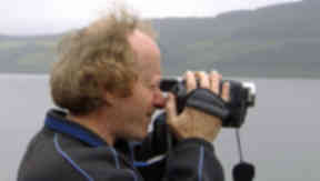 Loch Ness Monster hunter with camera at Loch Ness