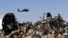 A helicopter flies over debris a day after the crash on October 31.