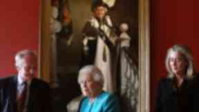 The Queen stands in front of the new portrait produced to mark her 90th birthday year.