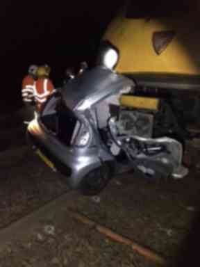 Level crossing: Car lodged underneath train.