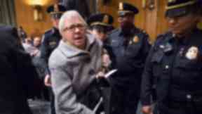 A protester was escorted her from the hearing room