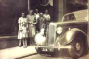 Sandy is the young lad with his father in front wearing a tie.