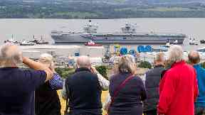 Crowds: People watch carrier make her way down the Firth of Forth.
