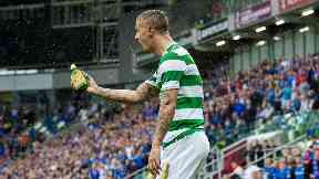 Leigh Griffiths picks up a bottle of Buckfast that was thrown in his direction.