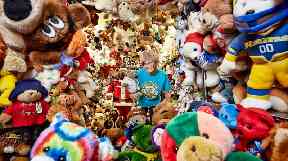 Jackie Miley is almost hidden among her collection of teddy bears.