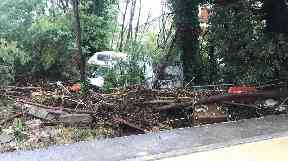 A camper van lies by the side of a road following floods in Leghorn.