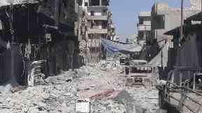 Destroyed buildings and vehicles in the deserted streets of Raqqa.