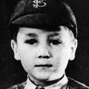A young John Lenon wearing a Strawberry Fields hat.