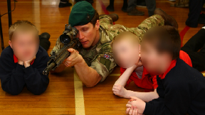Weapon: A Royal Marine commando shows an unloaded weapon to primary school pupils.