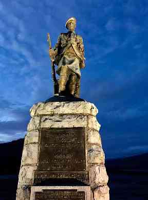 Inveraray's war memorial against a bright blue evening sky.