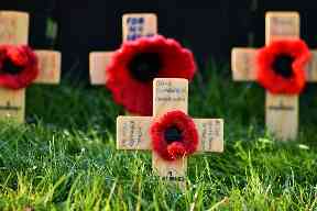 Wooden crosses with knitted poppies help to raise money for the cause.