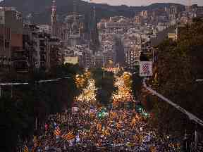 Demonstrators march in Barcelona backdropped by the Sagrada Familia church.