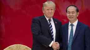 President Donald Trump and Vietnamese President Tran Dai Quang shake hands together during a State Dinner in Hanoi.