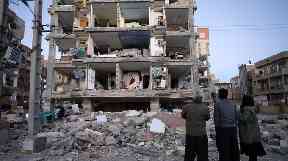 People look at buildings destroyed in the quake.