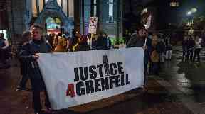 Marchers with posters and banners on the monthly slow and silent walk to demand justice for the victims of Grenfell.
