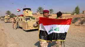Troops raised the Iraqi flag in territory liberated from IS near Rawa.