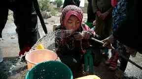 A girl drinks water from a well that was alleged to be contaminated with the bacterium Vibrio cholera.