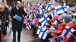 Schoolchildren greet Prince William as he arrives at auttasaari Comprehensive School in Helsinki.