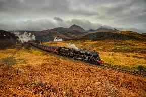 The Jacobite steam train ploughs through the countryside.