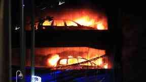 Blazing vehicles can be seen in the car park fire.