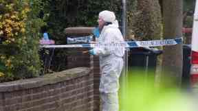 Forensic teams examine the Stockport property where a body was found.