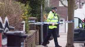 Police at a house in Reddish where a man's body was found buried in the garden.