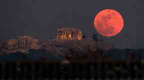 A super blue blood moon rises behind the 2,500-year-old Parthenon temple in Greece.