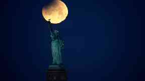 A supermoon pictured by The Statue of Liberty in New York.