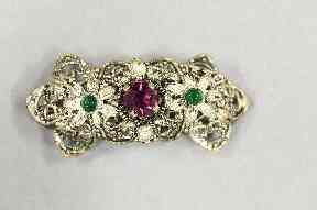 This brooch contains the three colours of the suffragette movement: green for hope, purple for dignity, and white - here silver - for purity.