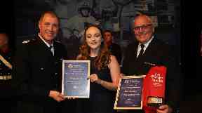 Two employees receive an award for their fundraising efforts