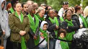 People arrive for the anniversary national minute silence and mosaic unveiling at the base of Grenfell Tower.