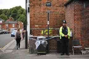 A police officer stands beside a sealed off bin