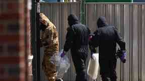 Investigators in chemical suits works behind screens erected in Rollestone Street, Salisbury