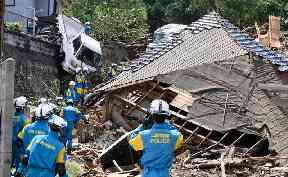 Rescuers prepare to start a search for missing people at the site of a landslide in Kumano town, Hiroshima prefecture