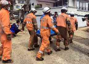 Emergency rescue teams recover the body of a flood victim in Hiroshima,