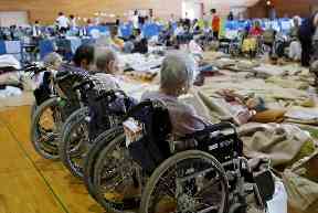 Elderly people from a nursing home take shelter following heavy rain, in Soja, Okayama prefecture