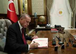 Turkey’s President Recep Tayyip Erdogan signs the decree for his new cabinet