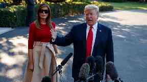First lady Melania Trump looks on as President Donald Trump speaks with reporters at the White House.
