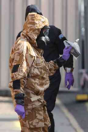 Investigators in chemical suits work behind screens erected in Rollestone Street, Salisbury