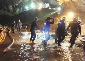 Rescuers hold an evacuated boy inside the Tham Luang Nang Non cave