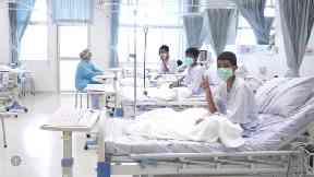 Three of the 12 boys in their hospital beds after being rescued.