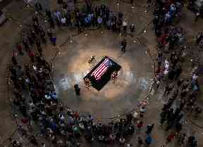 Tributes: Members of the public walk past the flag-draped coffin of John McCain.