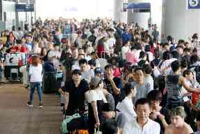 Stranded passengers queue up in lines to wait for special buses at Kansai International Airport