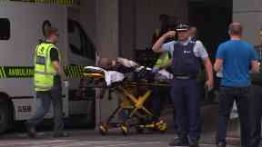 An injured man is taken to a waiting ambulance.
