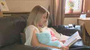 Laura looks at images of her baby son for comfort.