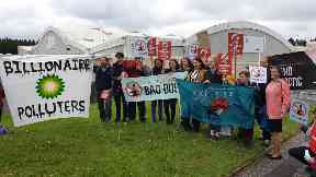 Dozens gathered outside the AGM with placards.