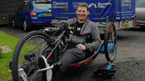 Stuart enjoys hobbies such as hand cycling despite his paralysis.
