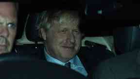 Boris Johnson leaves Westminster after losing his election motion.